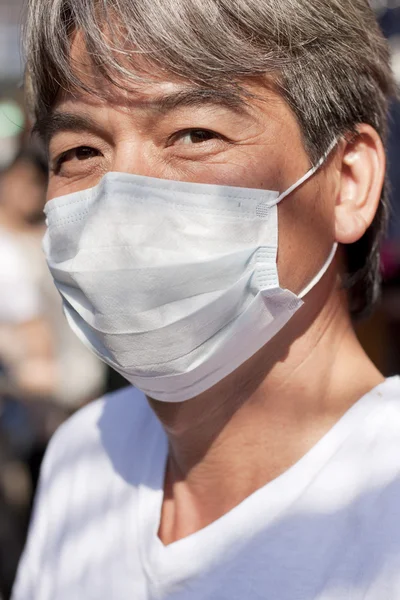 Rosto de ásia homem com roupas máscara olhando para câmera — Fotografia de Stock