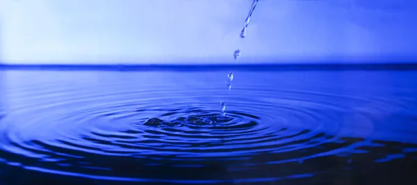 Gota de água para a superfície azul da água natural — Fotografia de Stock