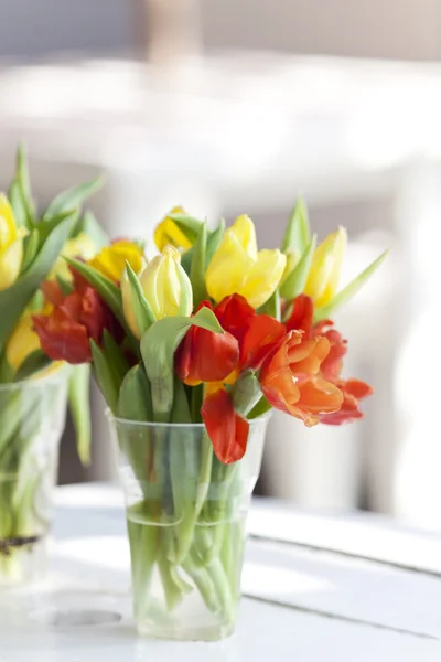 Flor de tulipán amarillo y blssom en un vaso decorado en mesa blanca — Foto de Stock