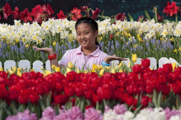 Ázsiai lány állt a kertben, a tulipán, mosolygós arc — стокове фото