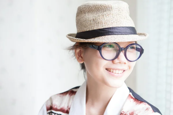 Asiatische Mädchen mit Brille und Hut lächelnd — Stockfoto