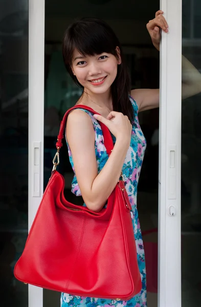 Asijské teenager držení červené módní taška s úsměvem tvář — Stock fotografie