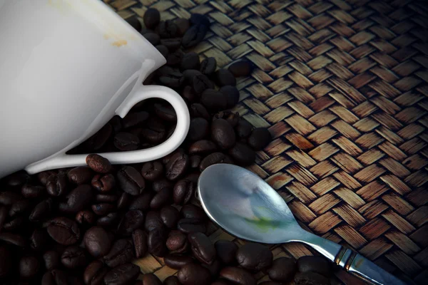 Copo branco e grão de café assado na mesa de madeira — Fotografia de Stock