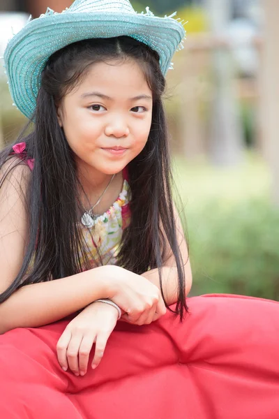 Beautiful asian girl in a hat on her head smiling — Stock Photo, Image