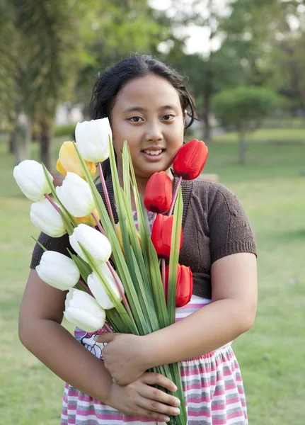 Dziewczyna przytrzymaj bukiet kwiatów tulipanów, stojąca w ogrodzie — Zdjęcie stockowe