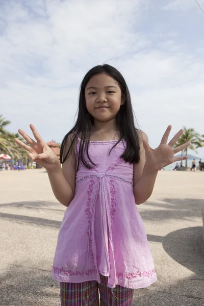 Aziatisch meisje Toon vinger handelend symbolen — Stockfoto