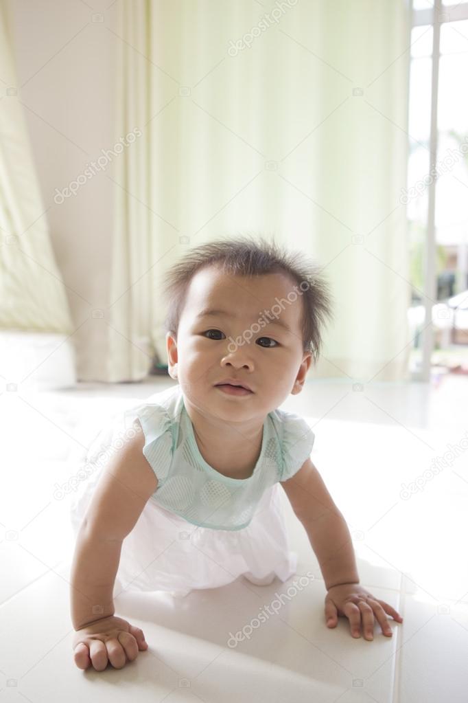 Face of asian baby 10 month aged crawling in living room