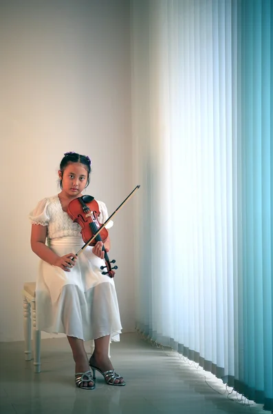 Menina tocando violino em um quarto — Fotografia de Stock