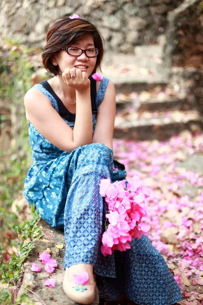 Asiatische Frau mit rosa Blumenstrauß in ihrer Hand lächelt vor die Kamera — Stockfoto