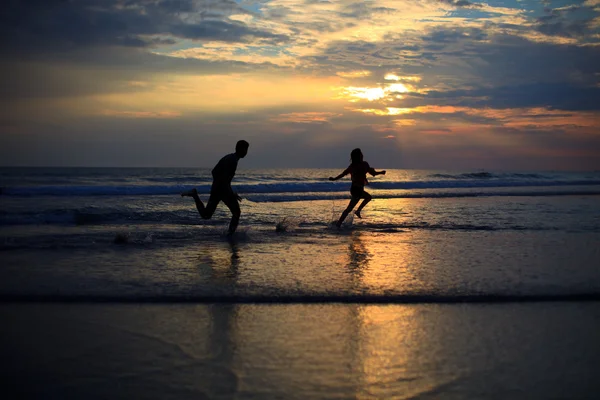 Casal feliz pulando na praia — Fotografia de Stock