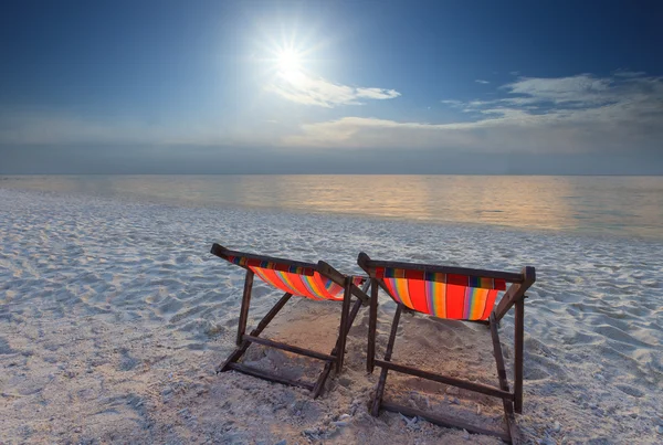 Paare Liegestühle Strand am Meer und Sonnenuntergang — Stockfoto