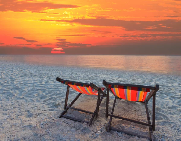 Paare Liegestühle Strand am Meer und Sonnenuntergang — Stockfoto