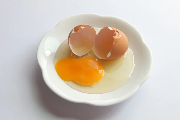 One broken egg on a plate — Stock Photo, Image