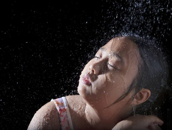 Cara de chica asiática jugando con verter agua con backgro negro — Foto de Stock