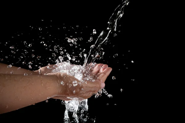 Hand and pouring water on black background — Stock Photo, Image