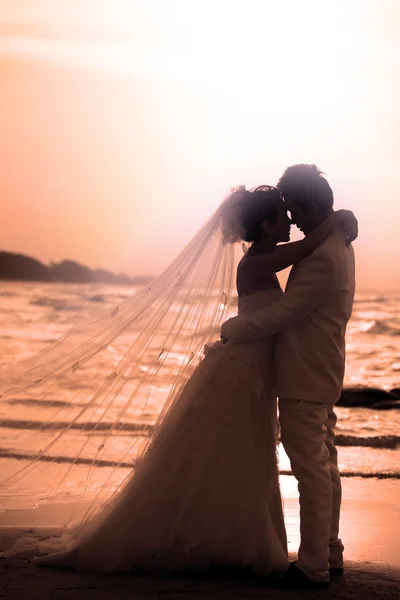 Sposo e sposa in piedi sul lato mare — Foto Stock