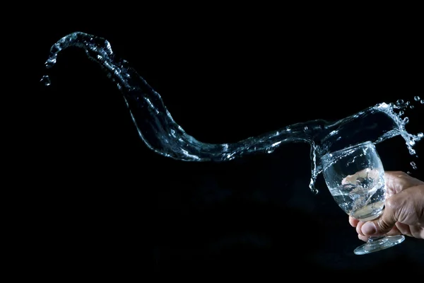 Mano y salpicaduras de agua sobre fondo negro — Foto de Stock