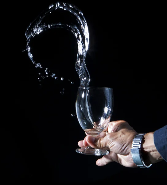 Hand and splashing water on black background — Stock Photo, Image