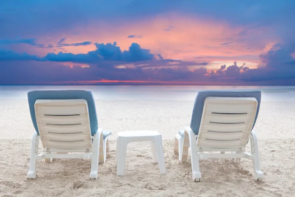 灰蒙蒙的天空背景下的白色沙滩椅沙滩的夫妻 — 图库照片