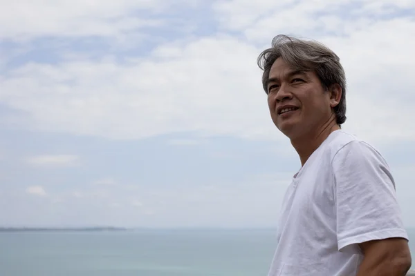 Gesicht eines vierzig Jahre alten asiatischen Mannes mit bewölktem Himmel — Stockfoto
