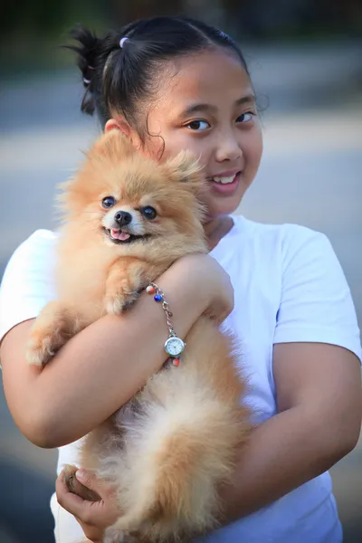 Face of girl holding pomeranian dog in home garden — Stock Photo, Image