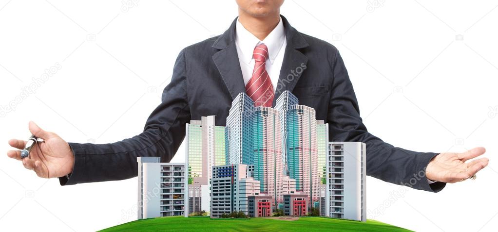 Business man and modern building on green grass field use for land management theme