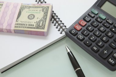 banknot ve kalem calculater not defterindeki yığını