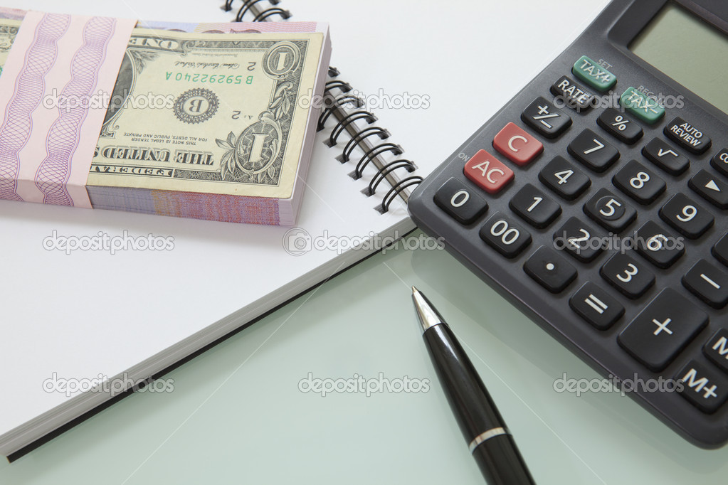 stack of bank note and pen calculater on note book