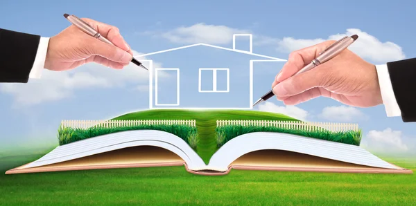 Business man writing new house on beautiful green field — Stock Photo, Image