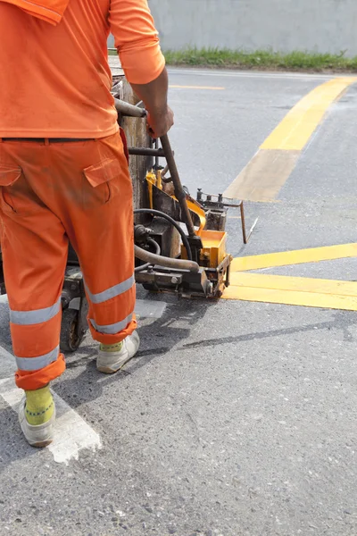 Maskin och arbetstagare vid användning på väg konstruktion för väg- och trafik underteckna målning — Stockfoto