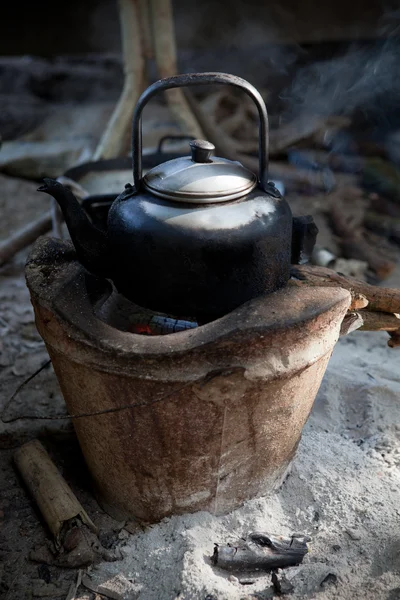 Alter gebrauchter Wasserkocher auf traditionellem Herd mit Wasserlauf — Stockfoto