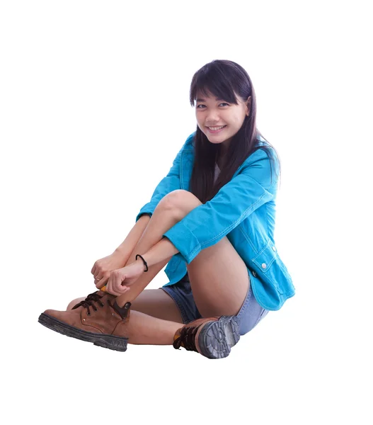 Oturan ve üzerinde beyaz izole ayakkabılarını giyen genç güzel Asyalı kadın — Stok fotoğraf