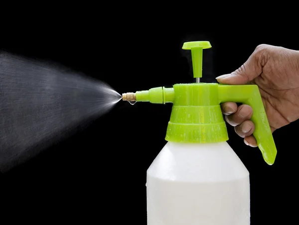 Fresh water spray from bottle by hand isolated on black — Stock Photo, Image