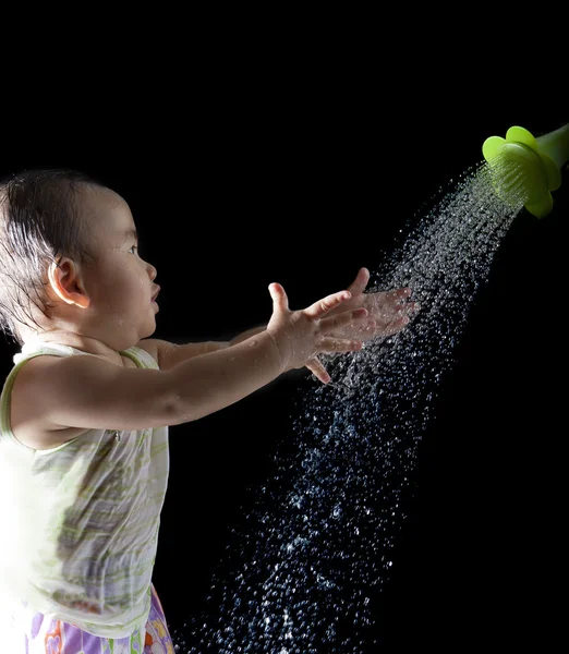 Archivo de cara de asiático bebé jugando con agua en negro backgroun — Foto de Stock
