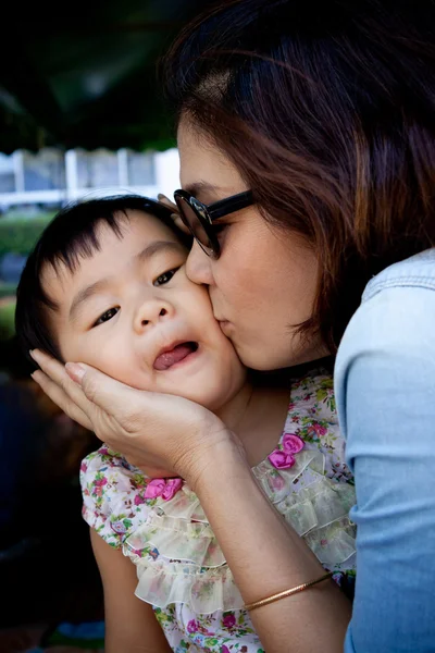 女の子子供とママの美しい顔と頬にキス — ストック写真