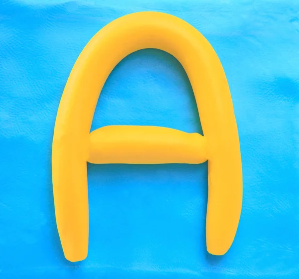 Yellow clay alphabet letter A — Stock Photo, Image
