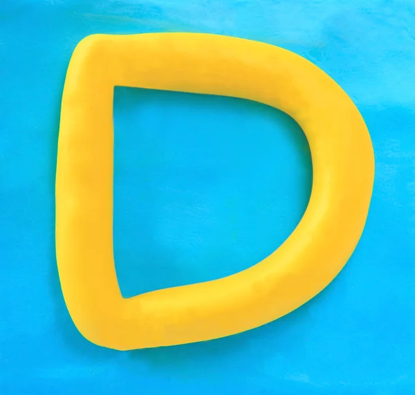 Yellow clay alphabet letter D — Stock Photo, Image