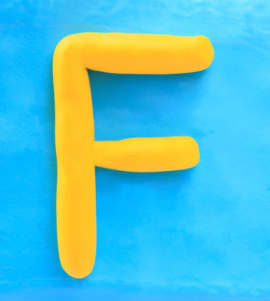 Yellow clay alphabet letter F — Stock Photo, Image