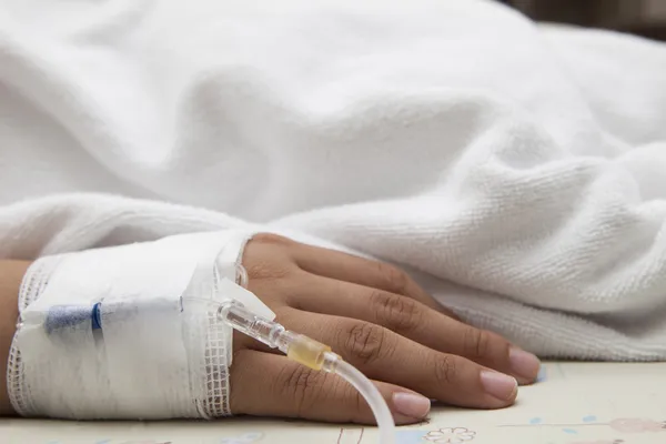 Mão do paciente deitado na cama do hospital — Fotografia de Stock