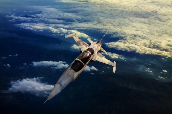 Military jet plane flying over mountain country view below
