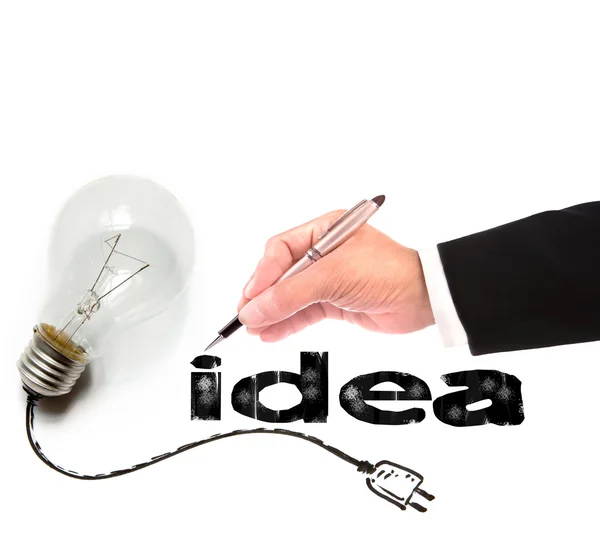 Mão de homem de negócios escrevendo ideia com lâmpada ao lado — Fotografia de Stock