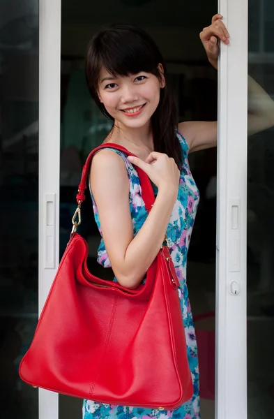 Asijské teen věku drží červený módní taška s usmívající se obličej — Stock fotografie
