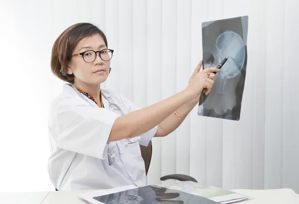 Female doctor watching on head skull x-ray film — Stock Photo, Image