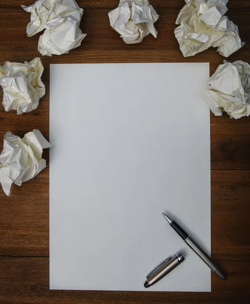 Pluma de lujo, papel blanco y papel arrugado en tabl de madera de trabajo —  Fotos de Stock