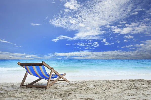 Ahşap açık mavi deniz suyu ile beyaz kum plaj sandalye güvertede bir — Stok fotoğraf