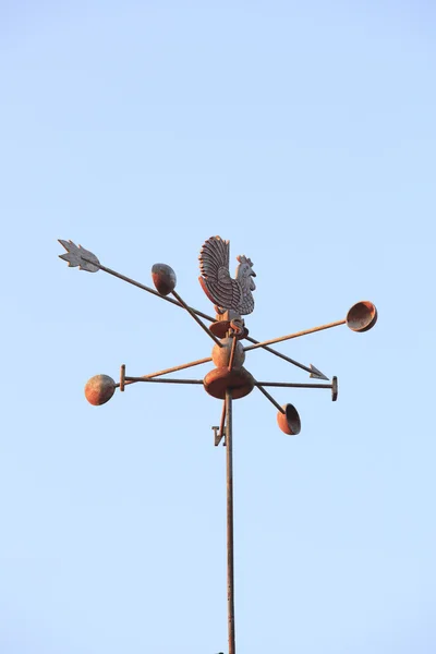 Weather Vane compass over house roof against blue sky background — Stock Photo, Image