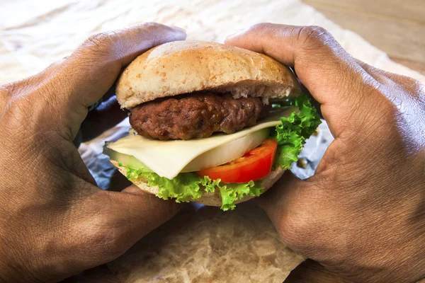 Ręka trzyma szynka burger sera raedy do jedzenia — Zdjęcie stockowe