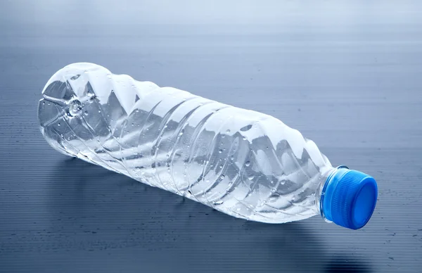 Lege plastic fles liggend op grijze achtergrond Rechtenvrije Stockafbeeldingen