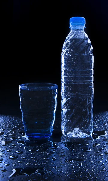 Szkło i butelka na świeżość wody pitnej na mokrej podłodze z c — Zdjęcie stockowe