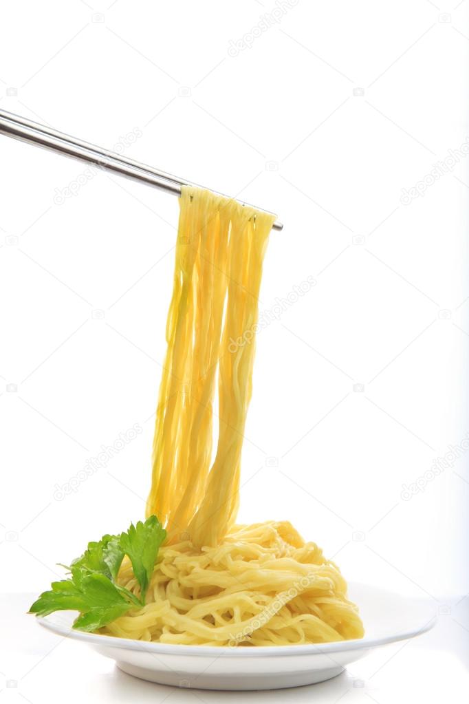 Steel chopstick holding chinese yellow eggs noodle on white disk